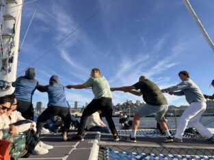 Samen de zeilen hijsen op de catamaran