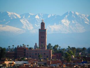 De Koutoubia-minaret in Marrakech met de besneeuwde Hoge Atlas op de achtergrond