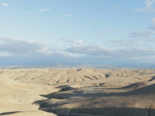 Glooiend stenen woestijnlandschap van Agafay met de Atlas aan de horizon