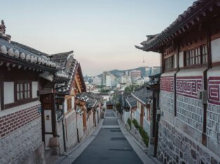 Steil straatje tussen hanokhuizen in Bukchon met de Namsan-toren in de verte