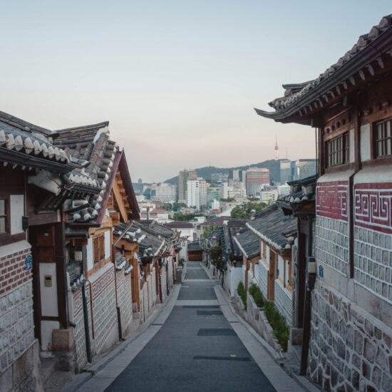 Steil straatje tussen hanokhuizen in Bukchon met de Namsan-toren in de verte