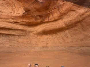 Met z'n allen onder de rotsboog in Monument Valley